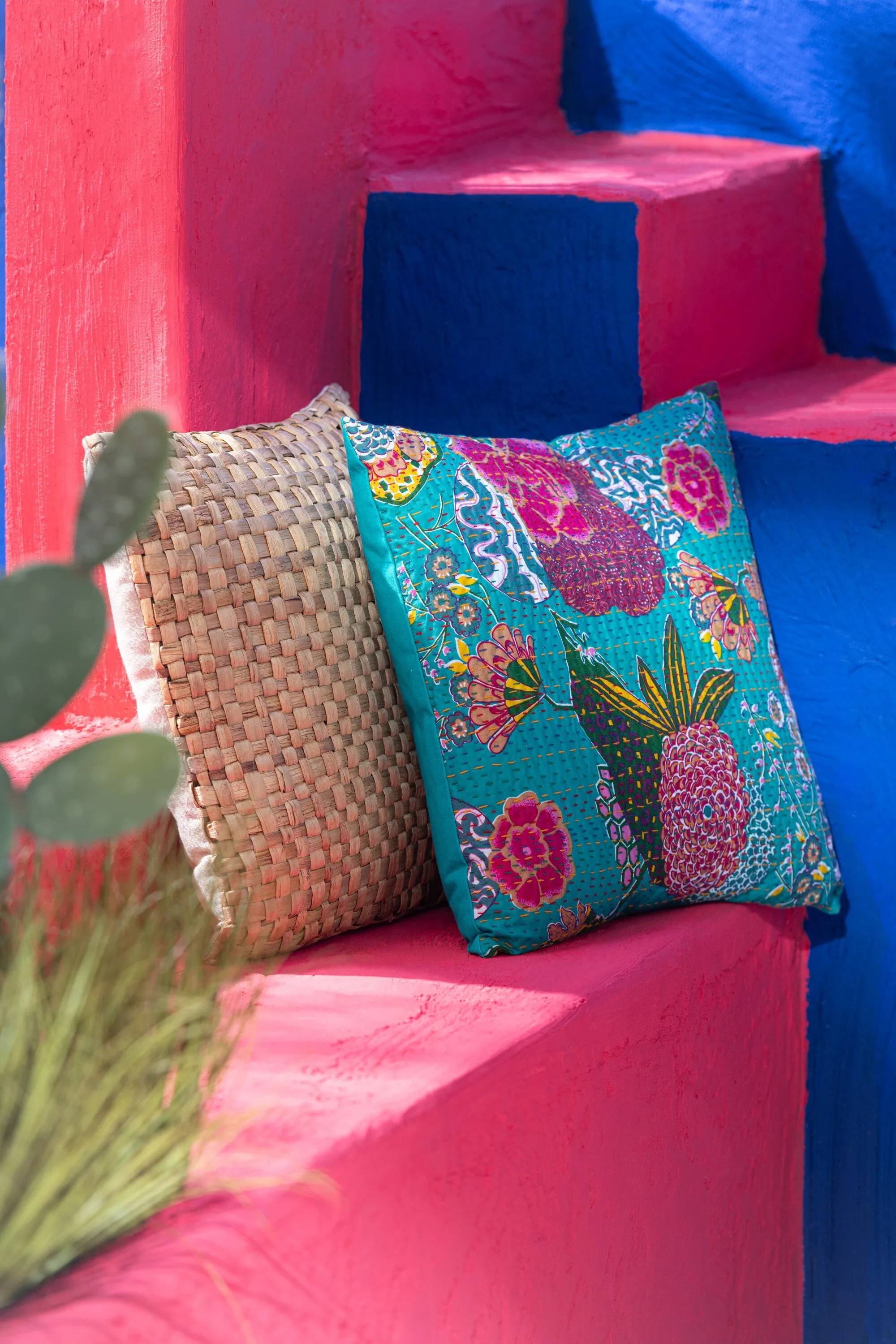 Cojín estampado de flores con pespuntes.