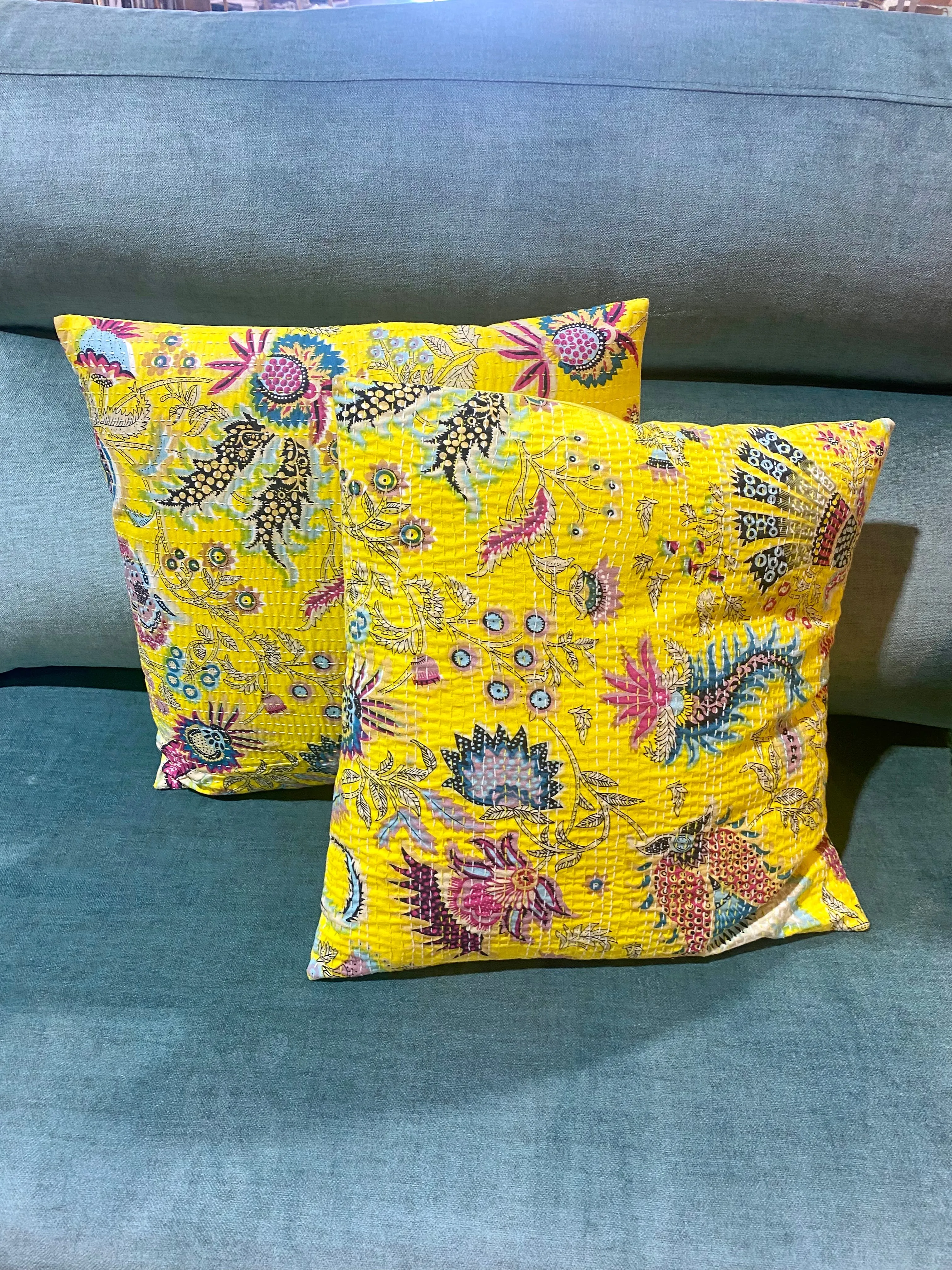 Cojín estampado de flores con pespuntes.