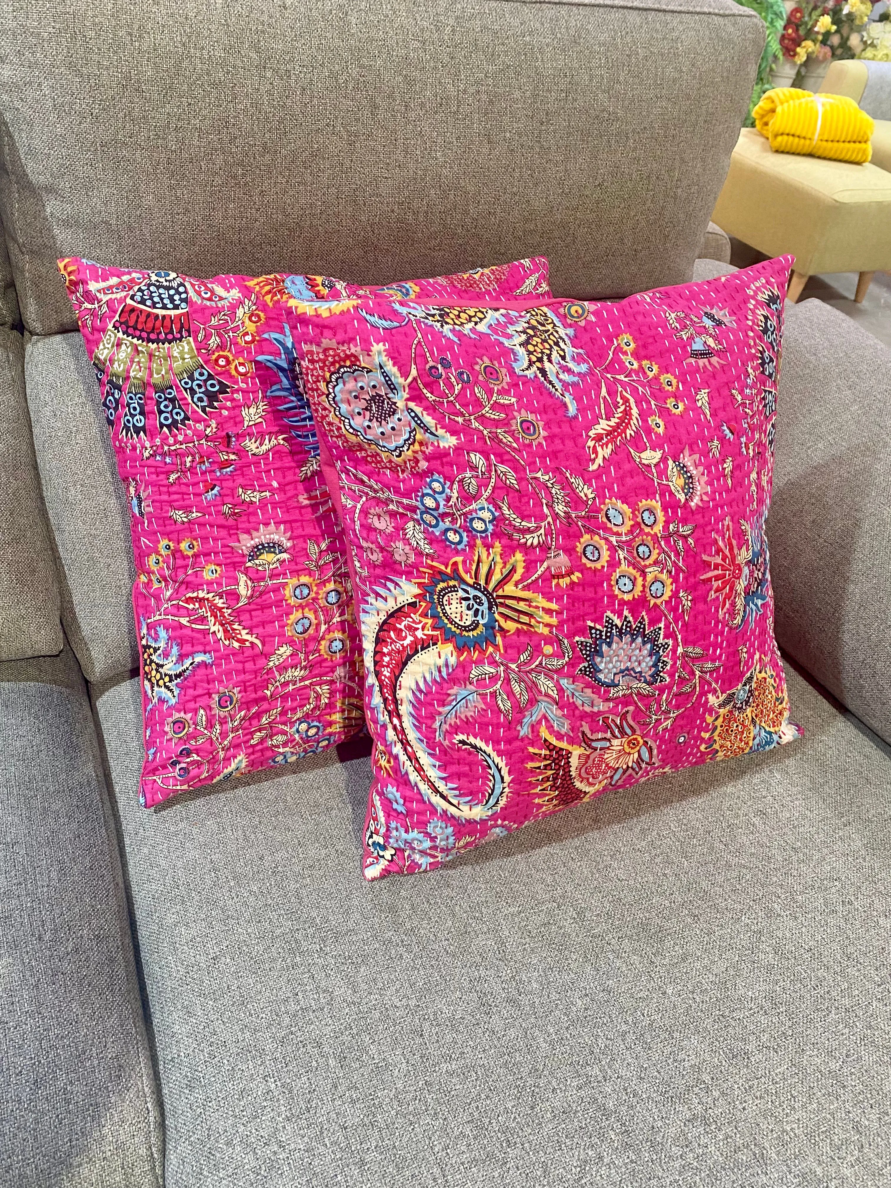 Cojín estampado de flores con pespuntes.