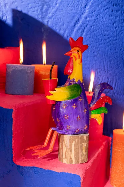 Gallo sentado sobre tronco, en metal de alegres y coloridos tonos.